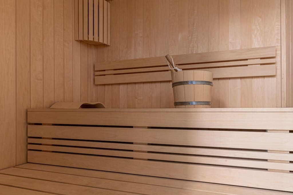 Un sauna en bois avec des bancs et un seau.