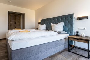 A modern bedroom with a large bed, a bedside table, and a wardrobe. - Holiday apartment with 1 bedroom (Kühlungsborn)