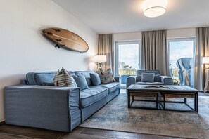 Un salon moderne avec un canapé, un fauteuil et une table basse.