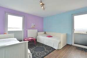 A bedroom with two beds, a window, a radiator, and a ceiling light fixture. - Holiday apartment in Glowe with swimming pool (Glowe)