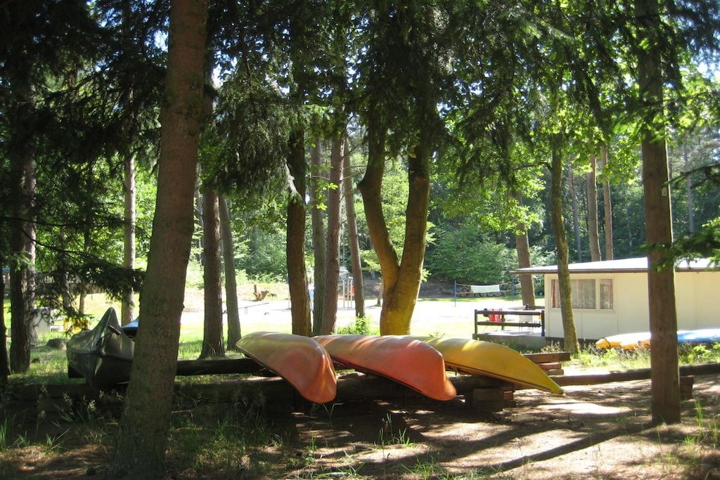 Un campeggio con kayak e un piccolo chalet.