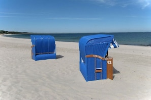 Two blue beach chairs on a sandy beach with a clear view of the ocean. - Holiday home in Glowe with swimming pool (Glowe)