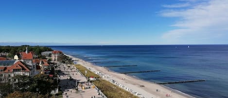 A coastal town with a promenade, beach, and buildings along the shore.