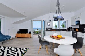 Ein modernes Interieur mit Essbereich, Küche und Blick ins Freie.