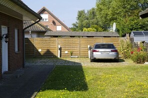 Ein Wohnhaus mit einem Auto auf der Auffahrt, einem Holzzaun und einer Ziegelhausfassade.