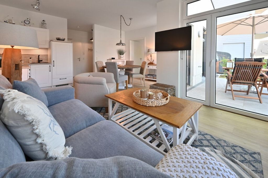 Un salon moderne avec un canapé, une table basse en bois et un téléviseur.