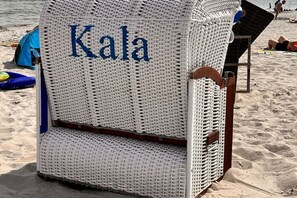 A beach chair with the word 'Kala' on it, placed on a sandy beach with a tent and other beach items in the background. - Holiday apartment in Juliusruh with Wi-Fi (Juliusruh)