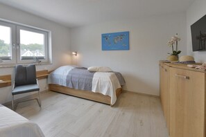 A bedroom with a bed, a chair, a desk, a wardrobe, a window, and a world map on the wall. - Holiday home with 3 bedrooms (Breege\/ Juliusruh OT Breege)