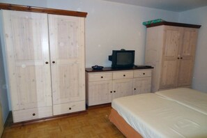 Ein Schlafzimmer mit einem Bett, einem Fernseher und zwei Kleiderschränken.