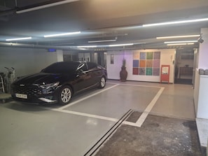Un estacionamiento con un coche negro estacionado en un espacio reservado.