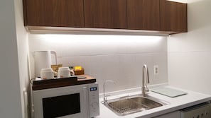 A modern kitchen with a built-in microwave, a stainless steel sink, and a coffee maker. - Wangsimni Stay Forest (Seoul)