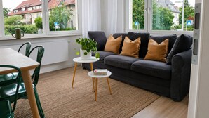 Een moderne woonkamer met een bank, een salontafel en uitzicht naar buiten.