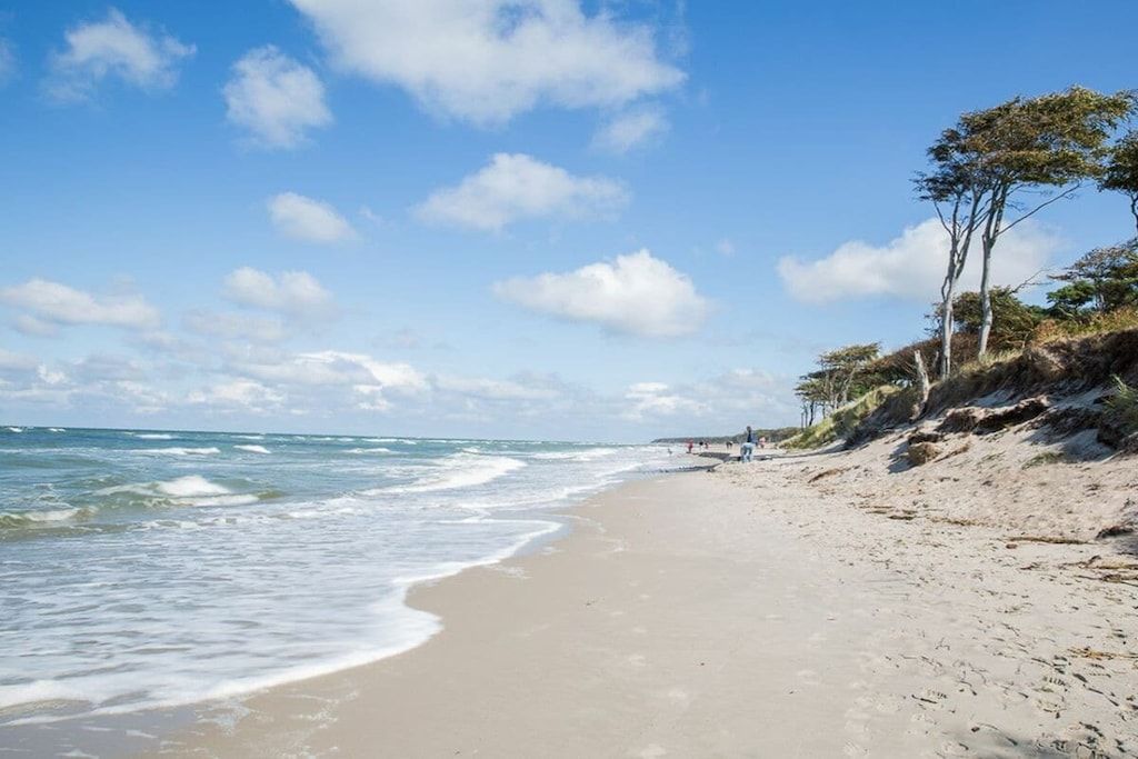A beach with a clear sky and calm sea.