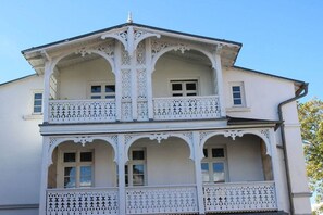 A two-story building with ornate white balconies and decorative railings. - Holiday apartment with 1 bedroom (Sassnitz)