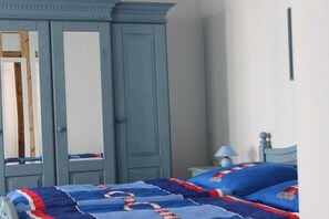 A bedroom with a bed, a wardrobe, and a nightstand. - Holiday apartment with 1 bedroom (Sassnitz)