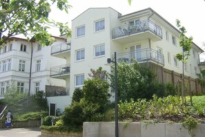 A multi-story residential building with balconies, a paved driveway, and surrounding greenery. - in the house "Holiday Idyll" (Seebad Ahlbeck)