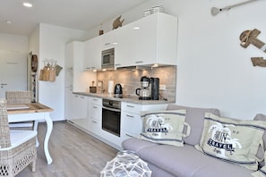 A compact kitchen with white cabinets, a microwave, and a coffee maker. - Holiday apartment in Glowe with swimming pool (Glowe)