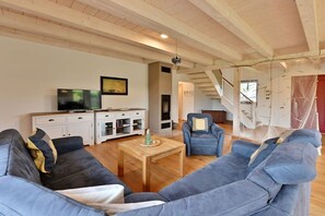 Ein Wohnzimmer mit einer Sofagarnitur, einem Couchtisch und einem Fernseher.