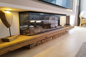 A modern living room with a fireplace, a sofa, and a television. - Holiday apartment with 2 bedrooms (Juliusruh)