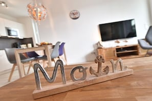 Et træbord med metalbogstaver, der staver 'MOM', og et anker.