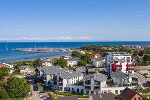 A coastal town with modern buildings, a marina, and a bridge in the distance. - Holiday apartment in Glowe with swimming pool (Glowe)