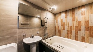 Un baño moderno con bañera, lavabo y ducha.