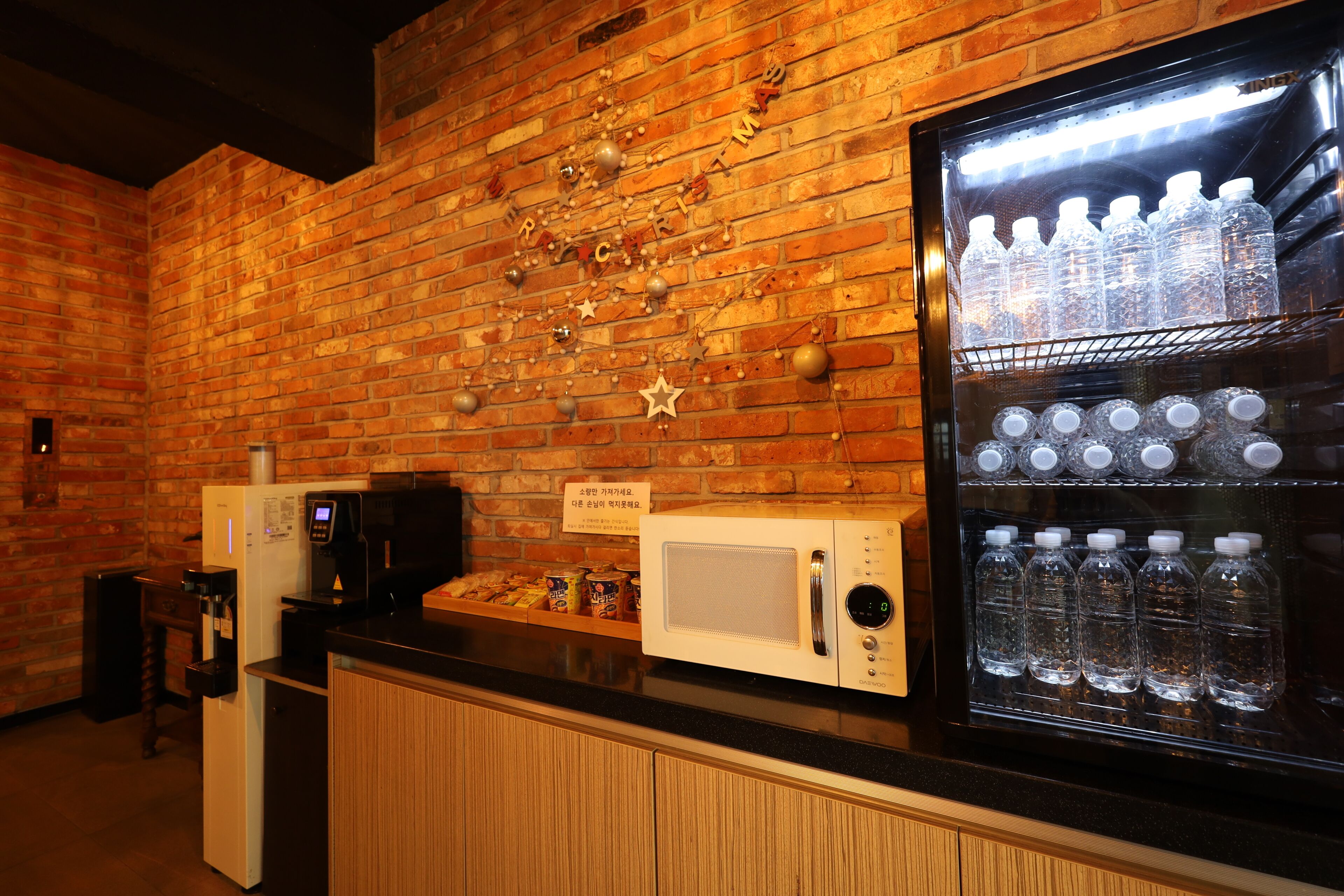 Un área de kitchenette equipada con refrigerador, microondas y cafetera.