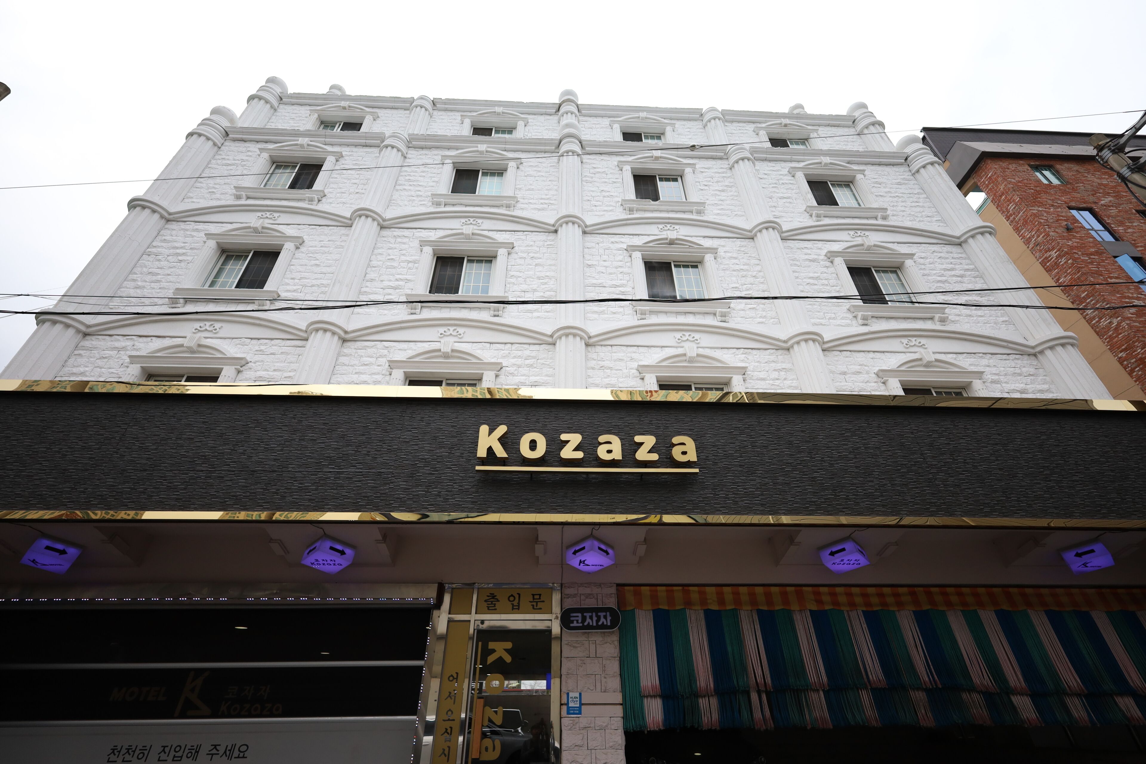 Un edificio con un letrero que dice 'Kozaza' y un letrero de motel.