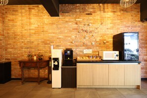 A kitchen with a brick wall, a refrigerator, a microwave, a coffee machine, and a wooden counter. - KOZAZA (Changwon-si)