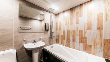 A bathroom with a bathtub, a sink, and a shower.