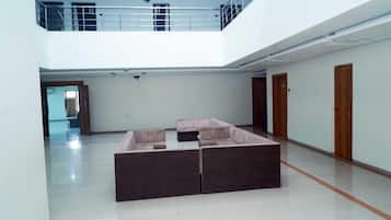 Un interior espacioso con techo alto, un entrepiso y un sofá modular.