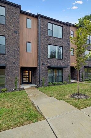 A modern multi-story building with a brick facade, large windows, and a flat roof. - Stunning Nash retreat w/ hot tub and rooftop view! (Nashville)