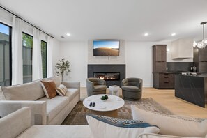 A modern living room with a fireplace, sofas, and a coffee table. - Stunning Nash retreat w/ hot tub and rooftop view! (Nashville)