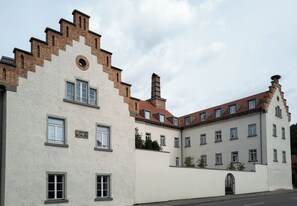 A building with a white facade, multiple windows, and a red-tiled roof. - Ludwig von Freyberg Suite – 104 m² in a historic castle (Stockach)