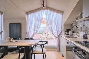 A compact kitchen with a dining area, a view through sheer curtains, and a cityscape. - Carlsen, Goat, Unique, Full City View Terrace (Istanbul)