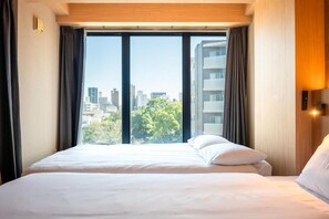 Una habitación de hotel con una cama grande, una ventana con cortinas y vistas a la ciudad.