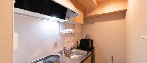 Une petite cuisine équipée d’une cuisinière, d’un évier et d’un petit réfrigérateur.
