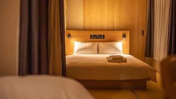 Una habitación de hotel con una cama grande, cabecero de madera y panel de control en la mesita de noche.