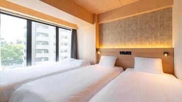 Een hotelkamer met twee bedden, grote ramen en een modern design.