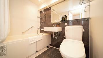 A modern bathroom with a bathtub, a toilet, and a shower.