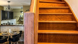 Una scala in legno con una cucina moderna sullo sfondo.