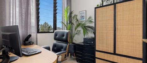 A modern office with a computer, a chair, a desk, a cabinet, and a window with curtains.