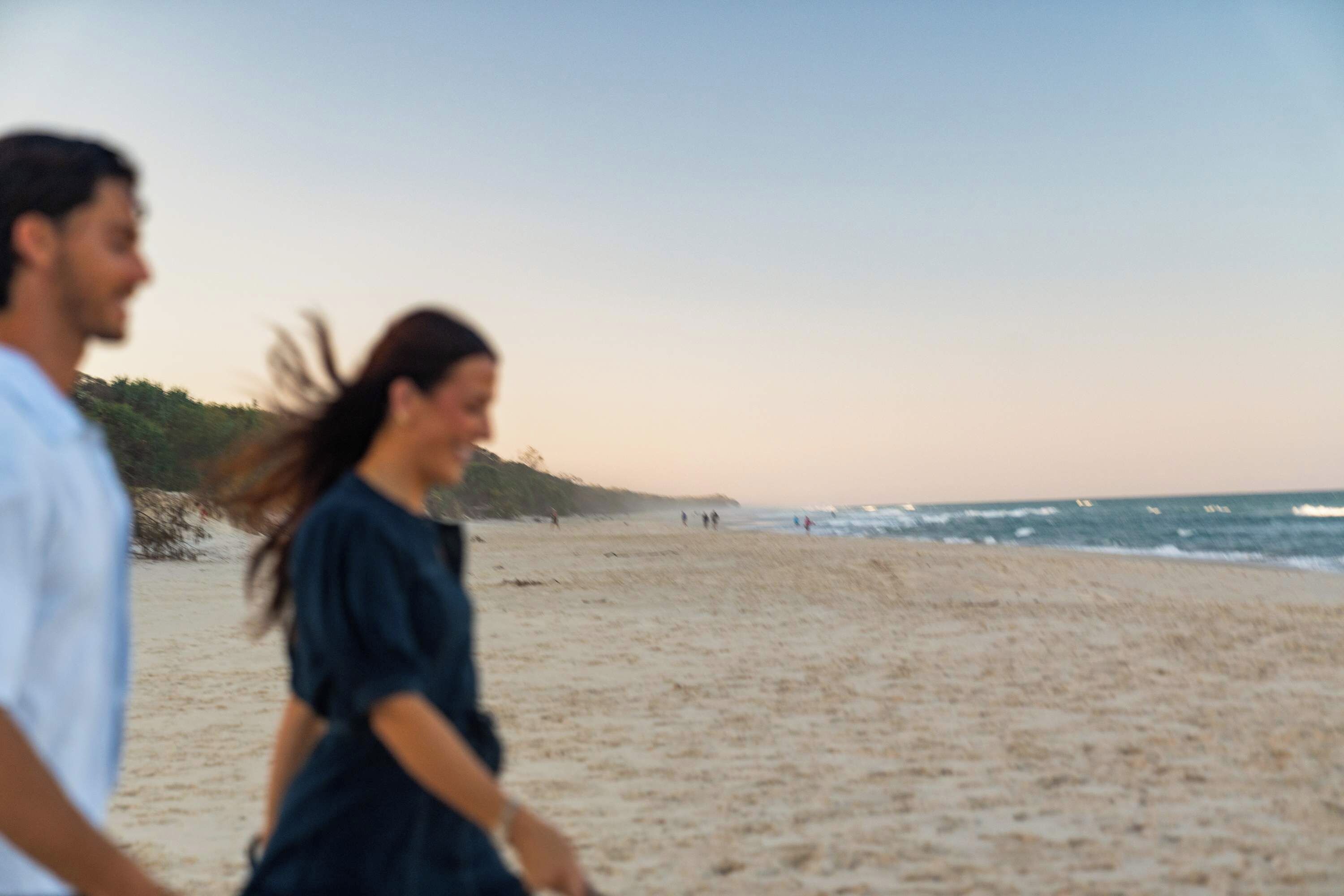 A beach scene with a sandy shore and the ocean in the background.