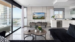 Een modern appartement met een zithoek, keuken en grote ramen met uitzicht over de stad.