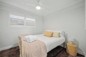 A bedroom with a bed, a bedside table, a lamp, and a ceiling fan. - Double Bay Delight with Parking - NEW (Double Bay)