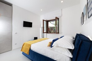 Ein modernes Schlafzimmer mit einem Bett, einem Fernseher und einem Fenster.
