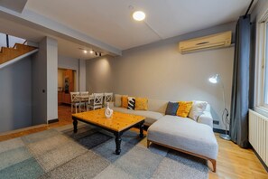 A modern living room with a sofa, a coffee table, and a dining area. - Spacious 4BR Private Townhouse with Exclusive Terrace (İstanbul)