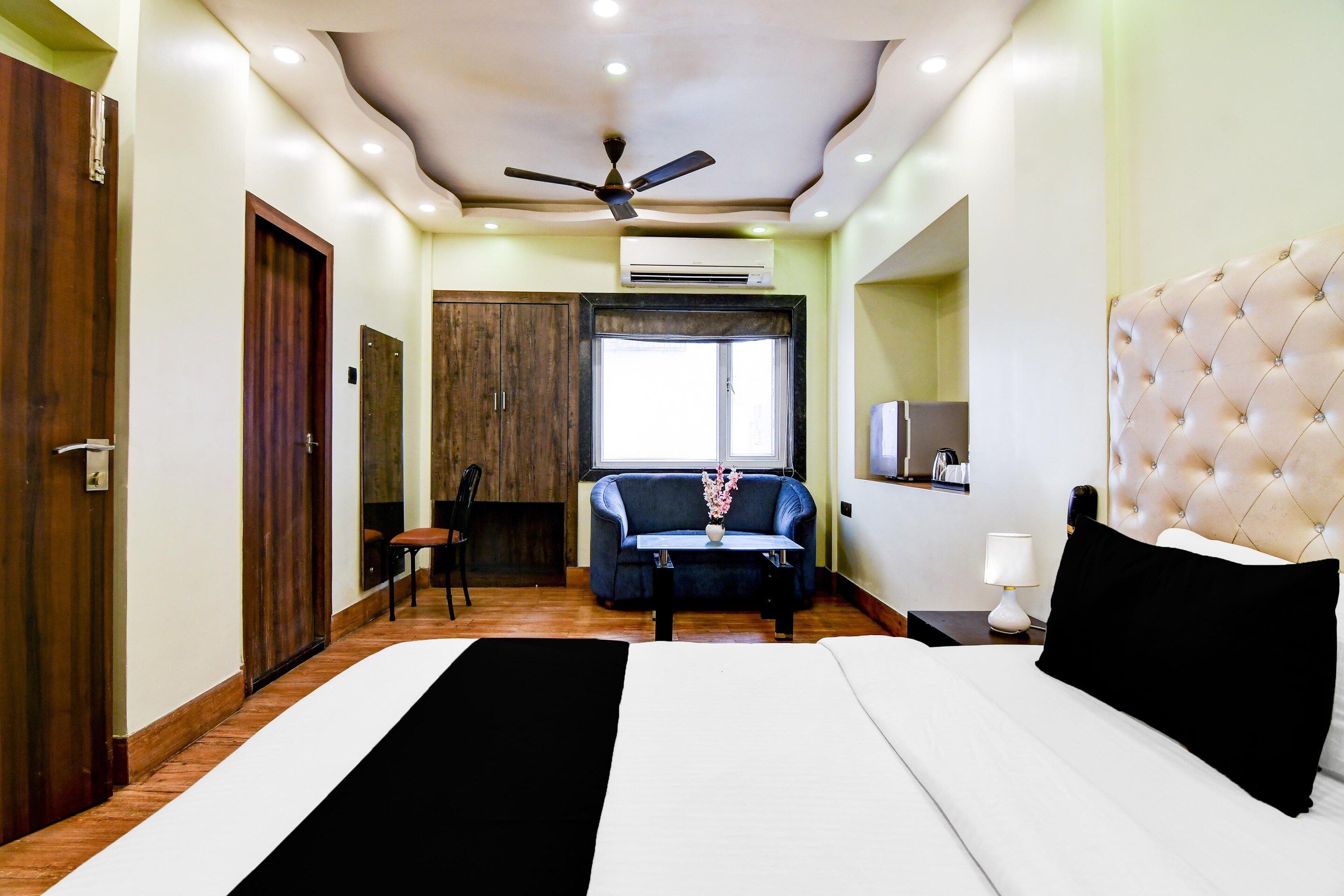 Une chambre d’hôtel équipée d’un lit, d’un canapé, d’un ventilateur de plafond et d’un appareil de climatisation.