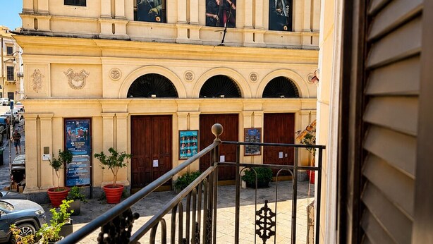 Un edifici amb un cartell que diu 'Real Teatro Santa Cecilia' i un balcó amb barana metàl·lica.
