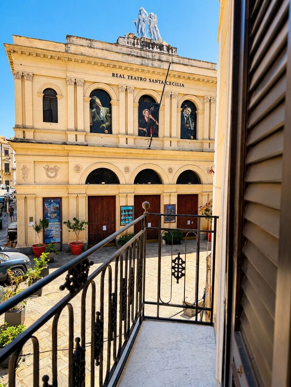 Un edificio con un letrero que dice 'Real Teatro Santa Cecilia' y un balcón con barandilla de metal.